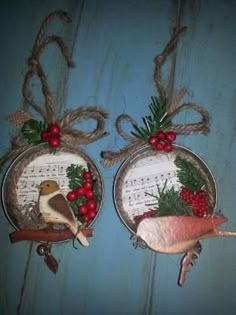 two christmas ornaments hanging from strings on a blue wall with music notes and holly berries