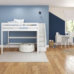 a white bunk bed sitting on top of a wooden floor next to a blue wall