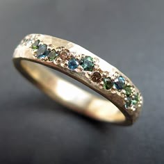 a gold ring with different colored stones on it