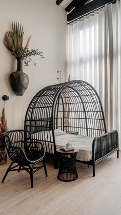 a living room filled with furniture and a bird cage next to a wall mounted plant