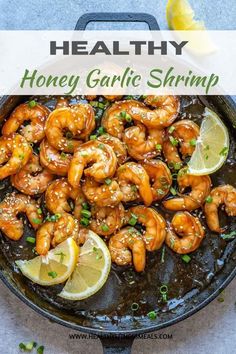 healthy honey garlic shrimp in a skillet with lemon wedges