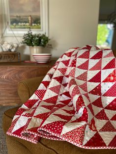 a red and white quilt sitting on top of a couch