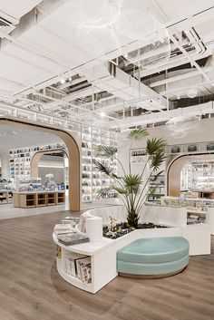 the inside of a store with lots of shelves and plants in it's center