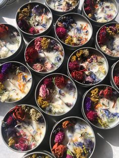 many bowls filled with different types of flowers