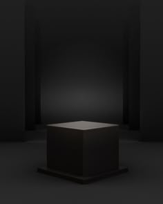 an empty black box in the middle of a dark room with light coming from it