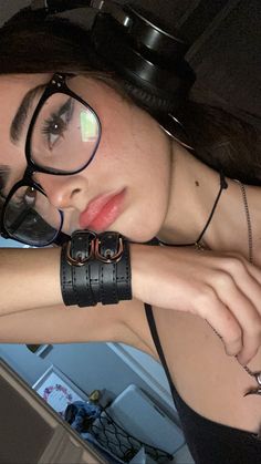 a woman wearing glasses and a leather bracelet