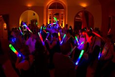 a group of people standing around each other in a room with lights on their arms