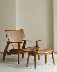 two wooden chairs sitting next to each other on top of a white carpeted floor