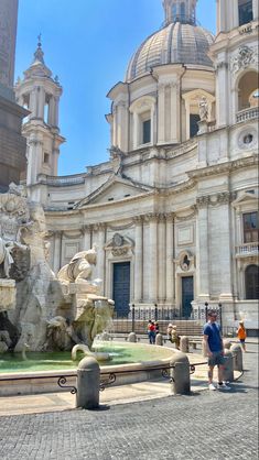 people are standing in front of a large building with statues on the outside and inside