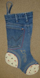 a pair of blue jeans with an embroidered boot on the bottom, and a small patch in the pocket