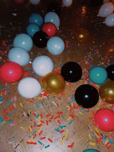 many balloons and confetti are scattered on the floor