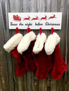 three christmas stockings hanging on a wooden fence