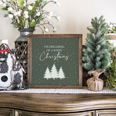 a wooden sign sitting on top of a mantle next to christmas decorations and trees in vases