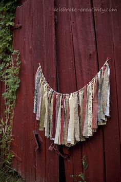 fabric strip garland hanging on the side of a red barn door with text overlay that reads fabric strip garland