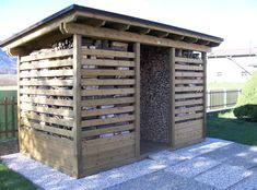 a wooden shelter with logs stacked in it