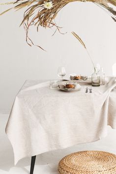 a white table topped with a plate of food next to a vase filled with flowers