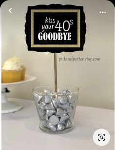 a cupcake on a stick with a sign that says kiss your 30's goodbye