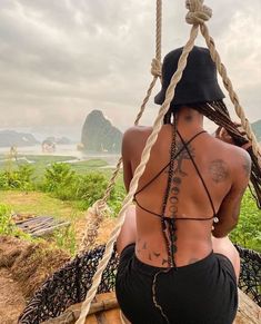 a woman sitting on top of a wooden swing