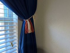 a curtain with tassels hanging from it's side in front of a window