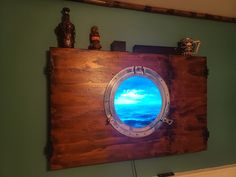 a wooden wall mounted with a porthole window and ocean scene painted on the side