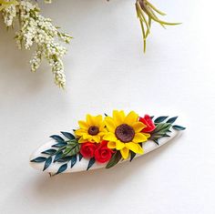 a white vase filled with flowers on top of a table next to a flower arrangement