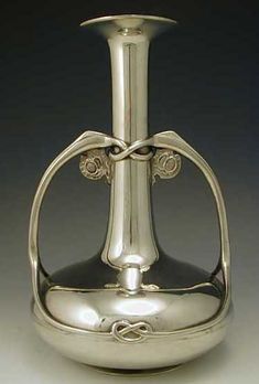 a silver vase sitting on top of a table