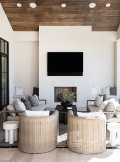 a living room with couches, chairs and a flat screen tv on the wall