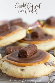 some cookies with chocolate and peanut butter on top are sitting on a cooling wire rack