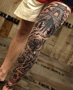 a man's leg with tattoos on it and a clock tower in the background