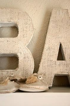 an old pair of shoes sits in front of the letters b and c on display