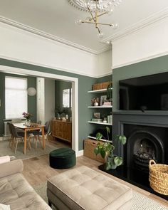 a living room filled with furniture and a flat screen tv mounted on a wall above a fire place