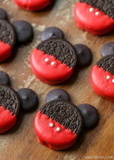 oreo cookies decorated with red and black icing on a wooden surface, ready to be eaten