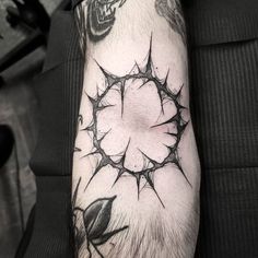 a man's arm with a black and white tattoo design on the forearm,