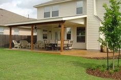 an outside patio with table and chairs in the grass next to a fenced in yard