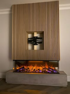 a fire place with a tv mounted on it's wall and some lights in the fireplace