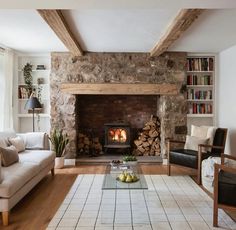 a living room filled with furniture and a fire place in the middle of a fireplace