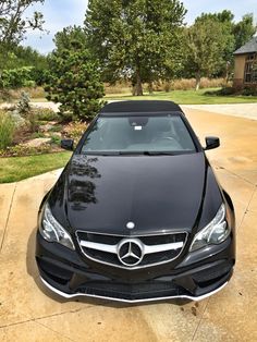 a black car is parked in the driveway