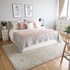 a white bed sitting in a bedroom on top of a hard wood floor next to a window