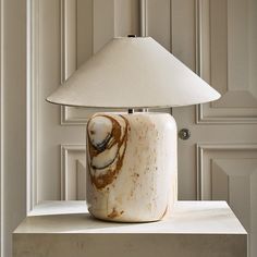 a lamp that is sitting on top of a table in front of a white door