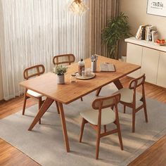 a wooden table with chairs around it in front of a white curtained room window