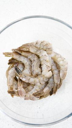 a glass bowl filled with shrimp on top of a table