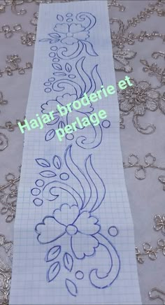 a piece of paper that is on top of a sheet of paper with some designs on it