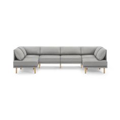 a gray sectional couch with wooden legs on a white background