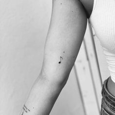 a woman's arm with a small tattoo on the left side of her arm