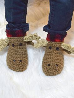 a person wearing crocheted slippers with moose head on it's feet