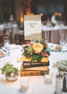 a table topped with books and flowers on top of each other