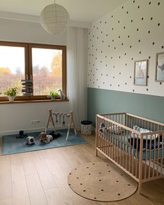 a baby's room with polka dot wallpaper and wooden flooring, including a crib