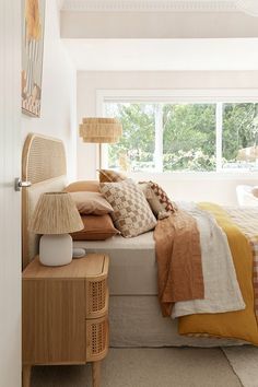 a bedroom with a bed, nightstands and window in it's center area