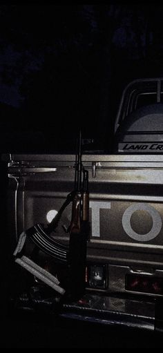 the back end of a pickup truck at night with its lights on and tools in the bed