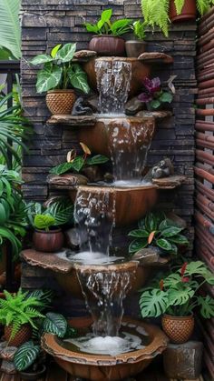 a water fountain surrounded by potted plants